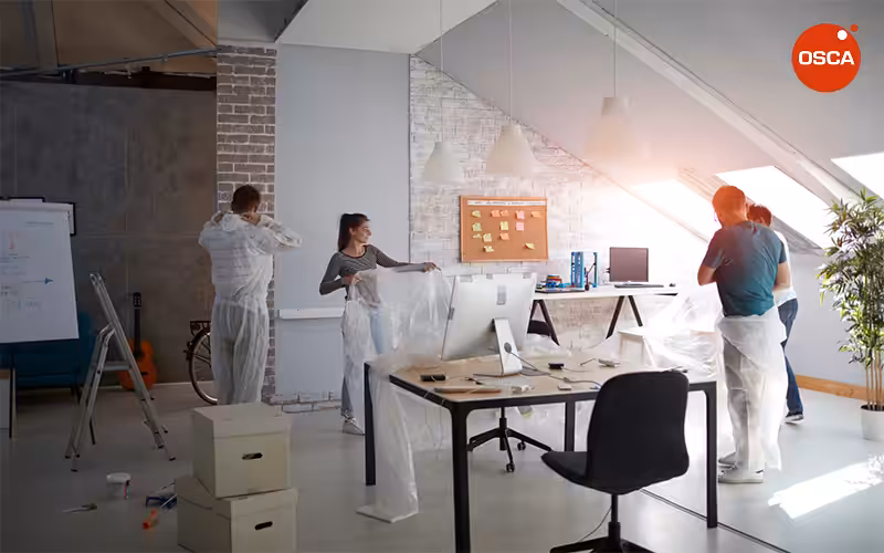 staff covering their work area with plastic sheets for office renovation